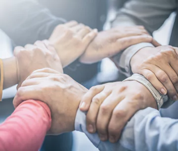 Team holding hands confidently